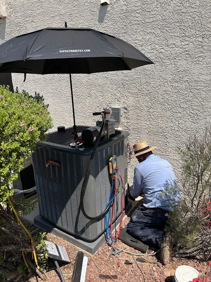 HVAC technician performing outdoor AC maintenance in Alton